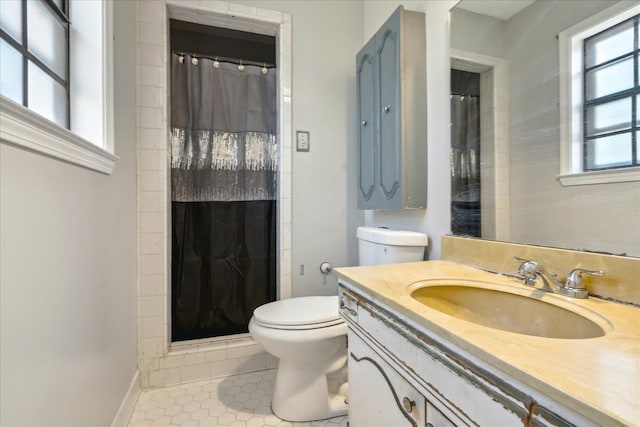 bathroom with tile patterned flooring, vanity, walk in shower, and toilet