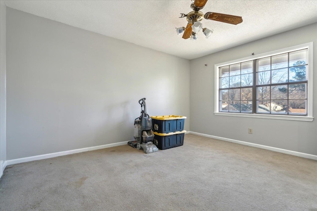 miscellaneous room featuring ceiling fan, carpet flooring, and a textured ceiling