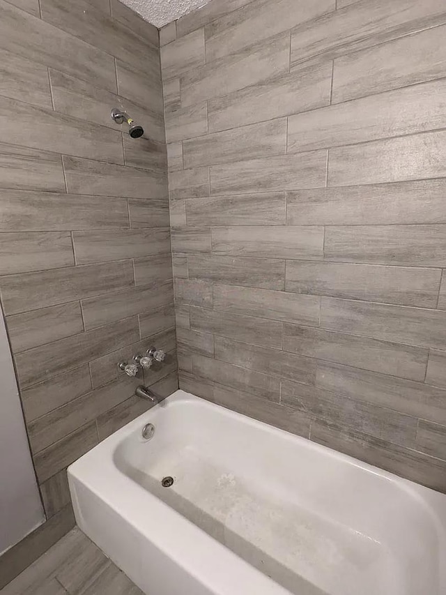 bathroom featuring tiled shower / bath