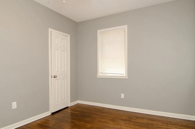 empty room featuring dark hardwood / wood-style flooring and a textured ceiling