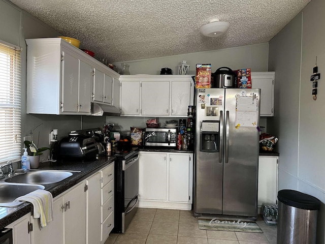 kitchen with light tile patterned floors, white cabinetry, appliances with stainless steel finishes, and vaulted ceiling