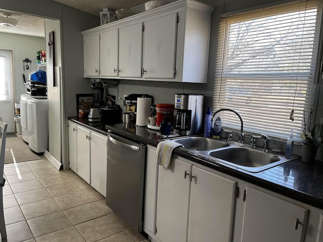 kitchen with sink, light tile patterned floors, stainless steel dishwasher, a textured ceiling, and white cabinets