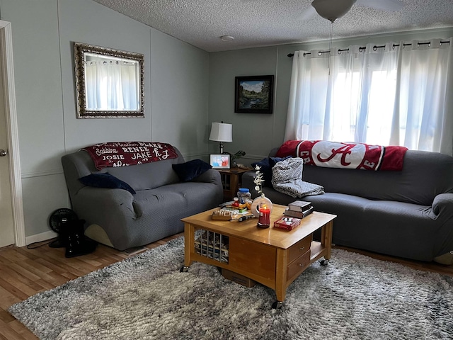 living room with lofted ceiling, ceiling fan, a textured ceiling, and hardwood / wood-style flooring