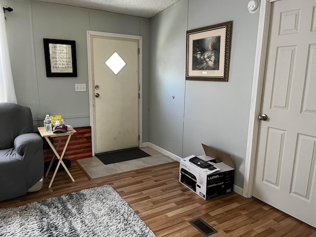 entryway featuring light wood-type flooring and a textured ceiling