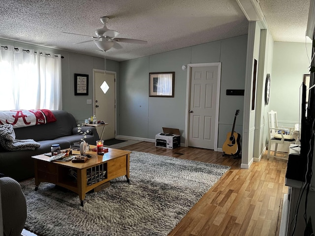 living room featuring a textured ceiling, hardwood / wood-style flooring, and ceiling fan