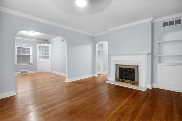 unfurnished living room with hardwood / wood-style flooring, ceiling fan, crown molding, and a tiled fireplace