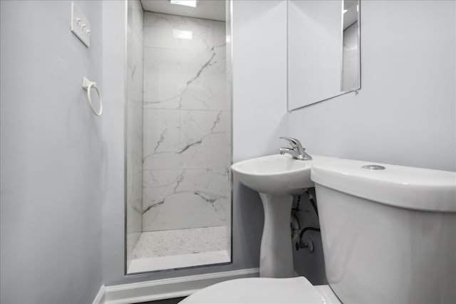 bathroom featuring a tile shower and toilet