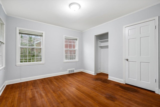 unfurnished bedroom with crown molding, multiple windows, and dark wood-type flooring