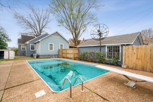 view of swimming pool with a diving board and central air condition unit