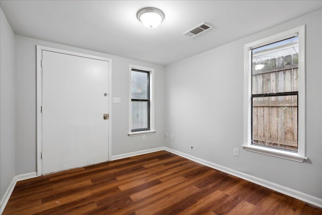 empty room featuring dark hardwood / wood-style floors and a healthy amount of sunlight