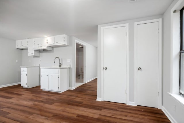 kitchen featuring white cabinets, sink, and dark wood-type flooring