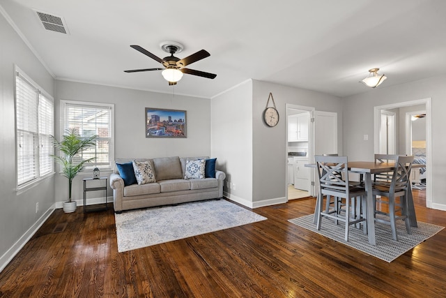 living room featuring ornamental molding, ceiling fan, and dark wood-type flooring