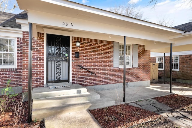 view of exterior entry featuring covered porch