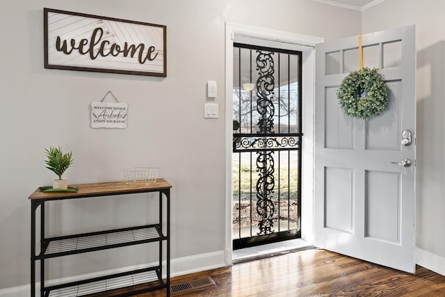 foyer entrance featuring crown molding, plenty of natural light, and hardwood / wood-style floors