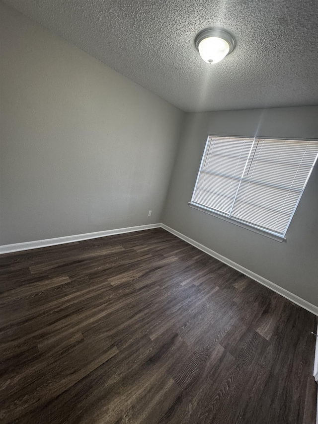 spare room with dark hardwood / wood-style flooring and a textured ceiling