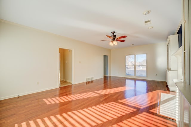 empty room with hardwood / wood-style flooring, ceiling fan, and crown molding