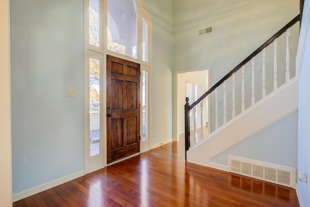 entryway featuring hardwood / wood-style floors and a high ceiling