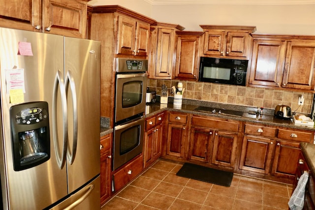 kitchen featuring black appliances, dark tile patterned flooring, decorative backsplash, dark stone countertops, and ornamental molding