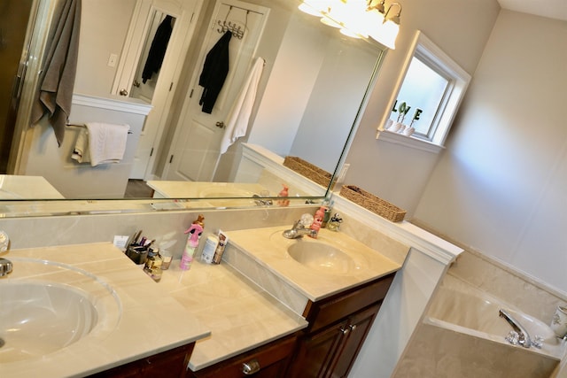 bathroom featuring a bathing tub, vanity, and an inviting chandelier