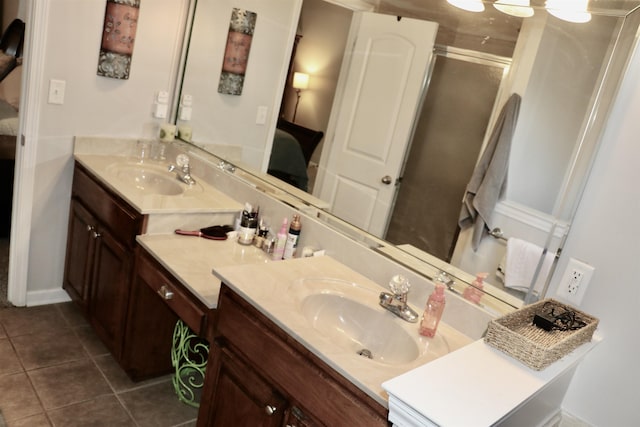 bathroom featuring tile patterned floors, vanity, and a shower with shower door