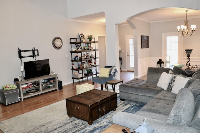 living room featuring hardwood / wood-style floors, crown molding, and a notable chandelier