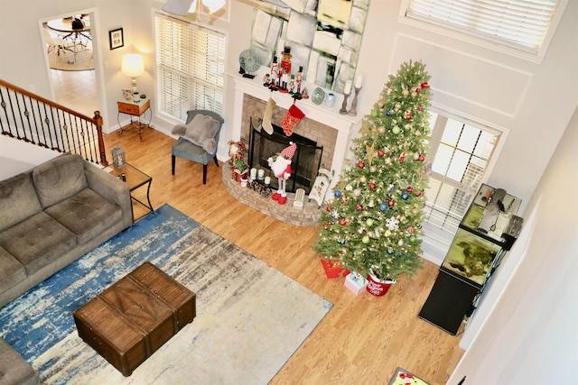 living room featuring a fireplace, hardwood / wood-style floors, and a towering ceiling