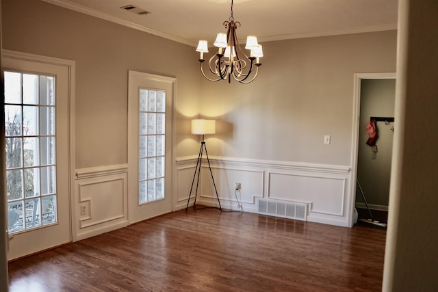 unfurnished dining area featuring crown molding, dark wood-type flooring, and an inviting chandelier