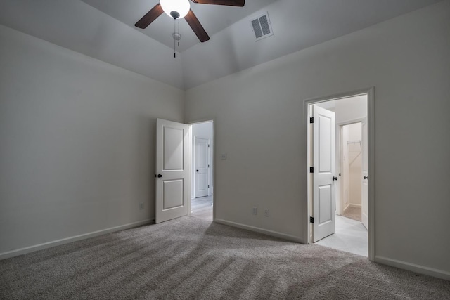 spare room featuring light colored carpet, vaulted ceiling, and ceiling fan