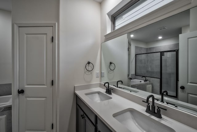 bathroom with vanity and shower with separate bathtub