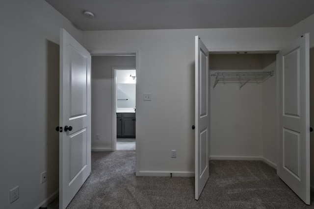 unfurnished bedroom featuring dark colored carpet and a closet