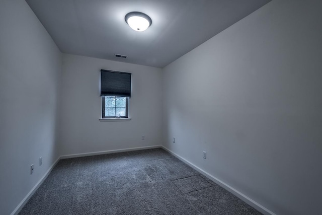 unfurnished room with dark carpet