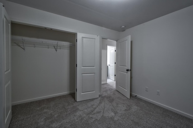 unfurnished bedroom featuring dark carpet and a closet