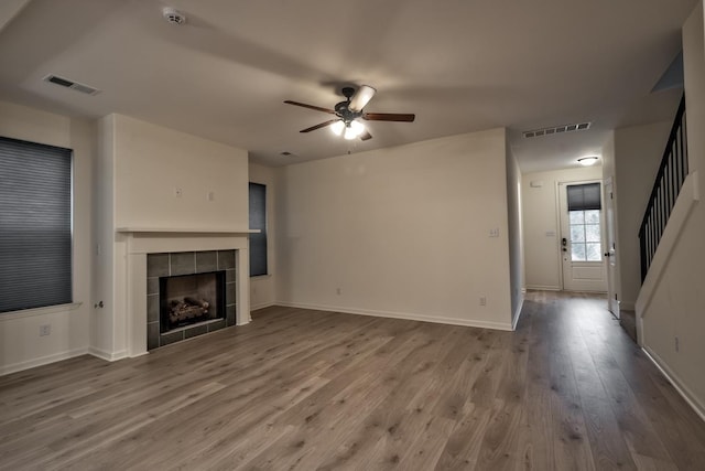 unfurnished living room with a fireplace, hardwood / wood-style flooring, and ceiling fan