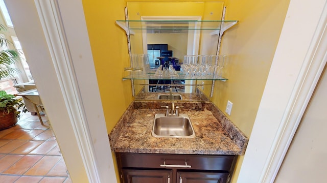 bar with sink and light tile patterned floors