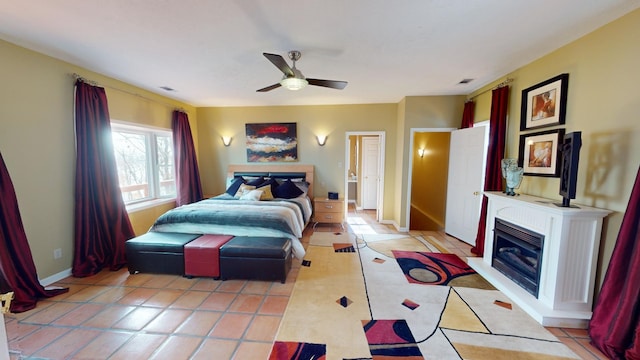 tiled bedroom with a fireplace and ceiling fan