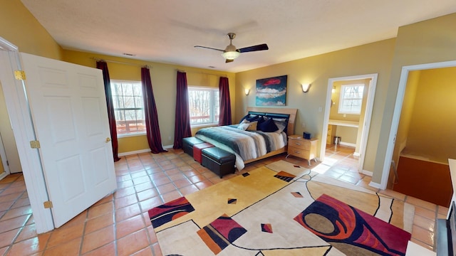 tiled bedroom with ceiling fan and ensuite bath