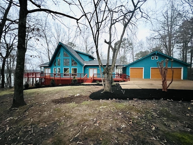 back of property with a garage, an outbuilding, and a wooden deck