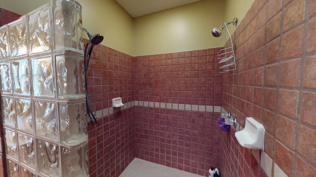 bathroom with a shower and tile walls