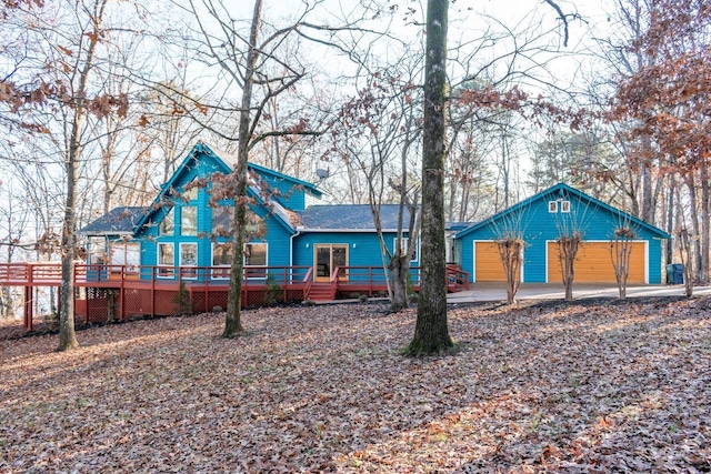 back of house with a garage and a wooden deck