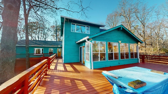 rear view of property with a wooden deck and a sunroom