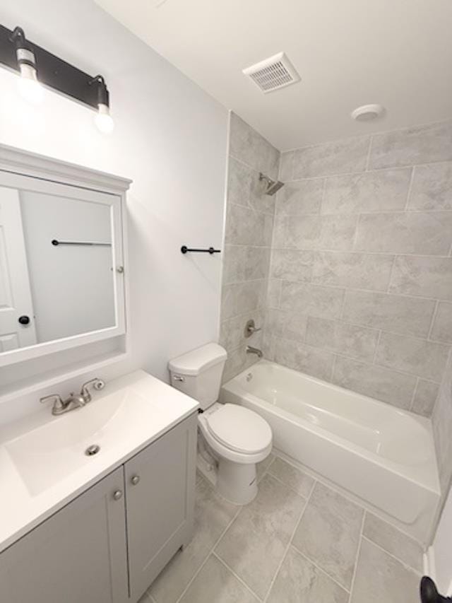 full bathroom featuring tile patterned flooring, vanity, toilet, and tiled shower / bath