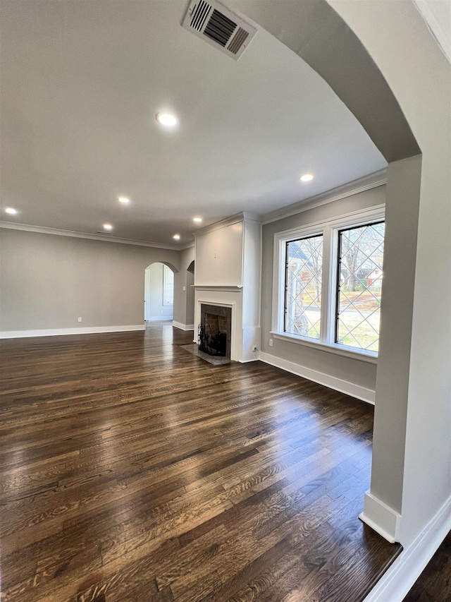 unfurnished living room with ornamental molding and dark wood-type flooring