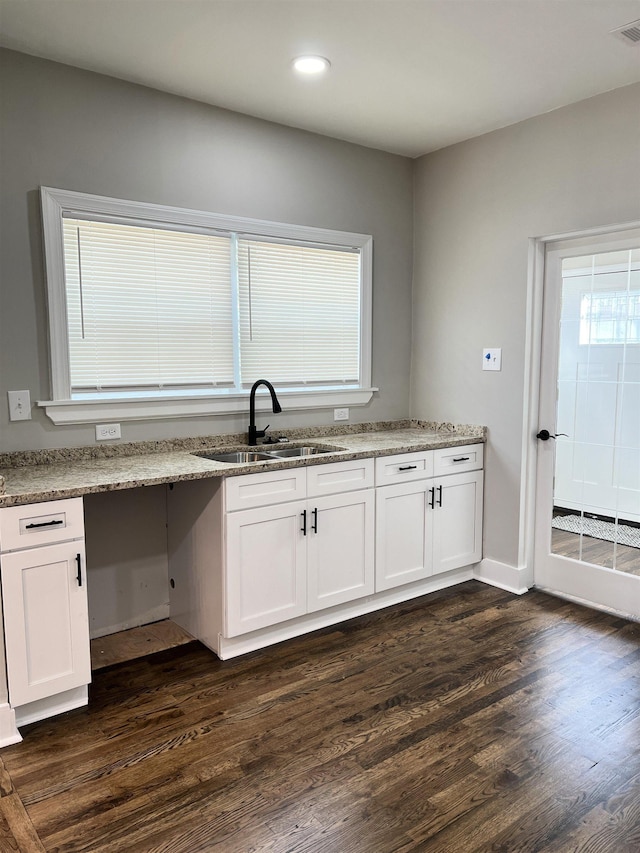 kitchen with dark hardwood / wood-style flooring, white cabinets, and a healthy amount of sunlight