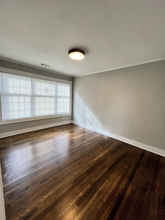 spare room with dark hardwood / wood-style flooring and ornamental molding