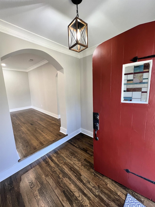 entrance foyer with dark hardwood / wood-style floors and ornamental molding