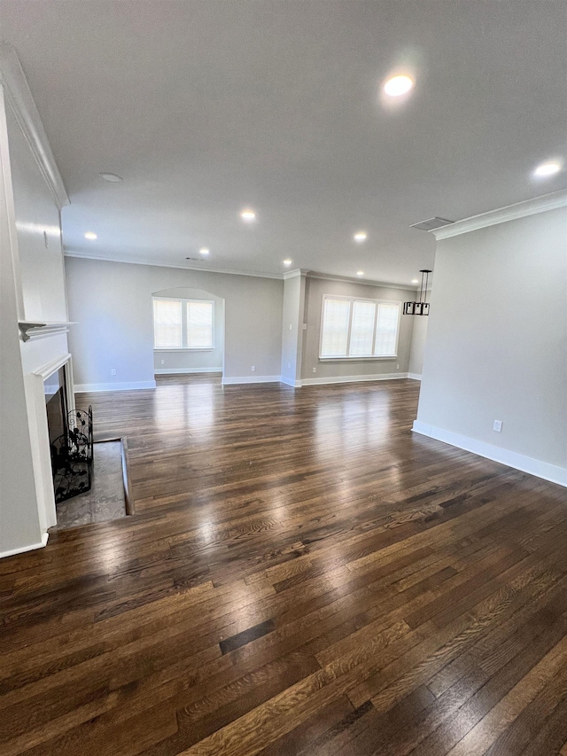 unfurnished living room featuring a textured ceiling, dark hardwood / wood-style flooring, and crown molding