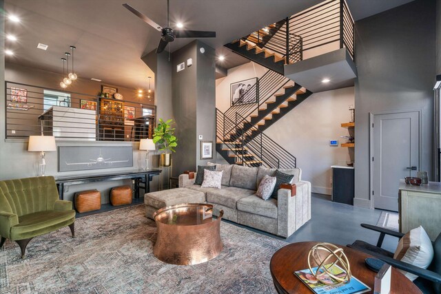 living room with concrete flooring and a towering ceiling