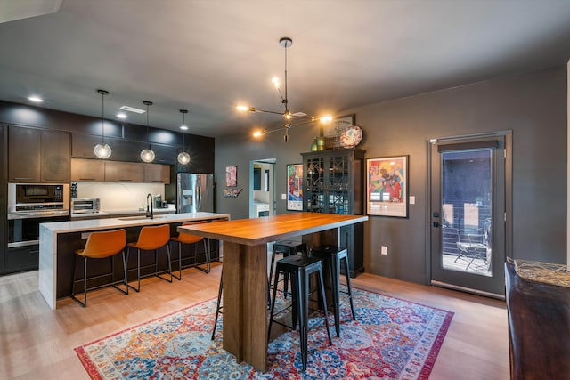 dining space featuring ceiling fan, light hardwood / wood-style floors, and sink