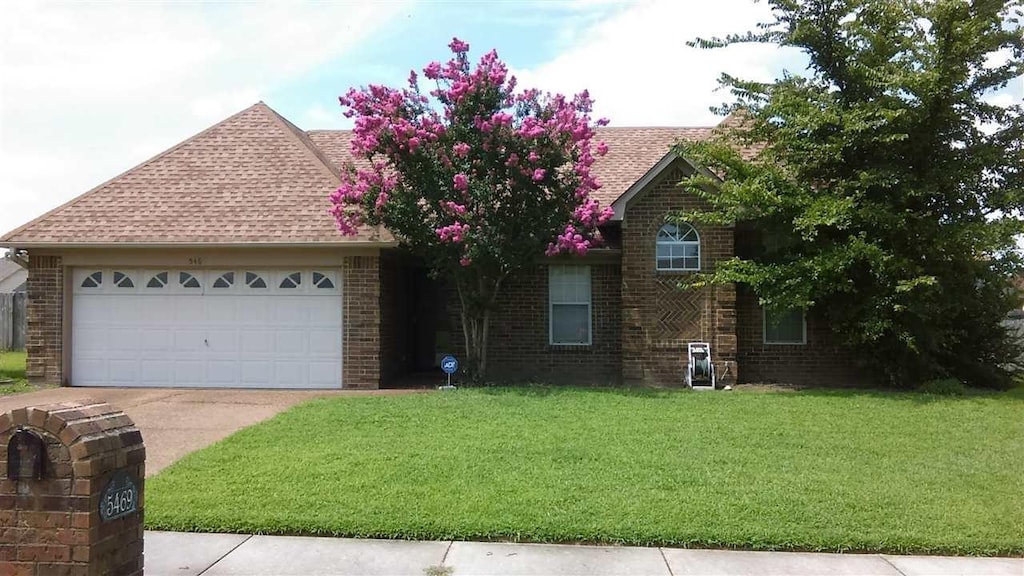 view of front of property with a garage and a front lawn