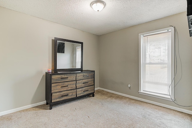 bedroom featuring light colored carpet and a textured ceiling